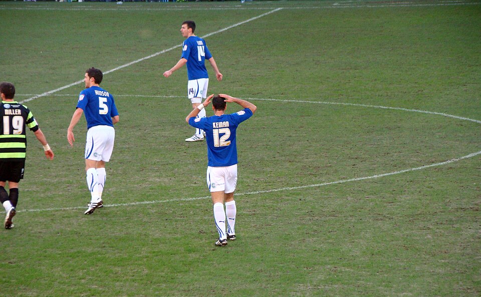 Jugadores forman una barrera defensiva en un partido de fútbol